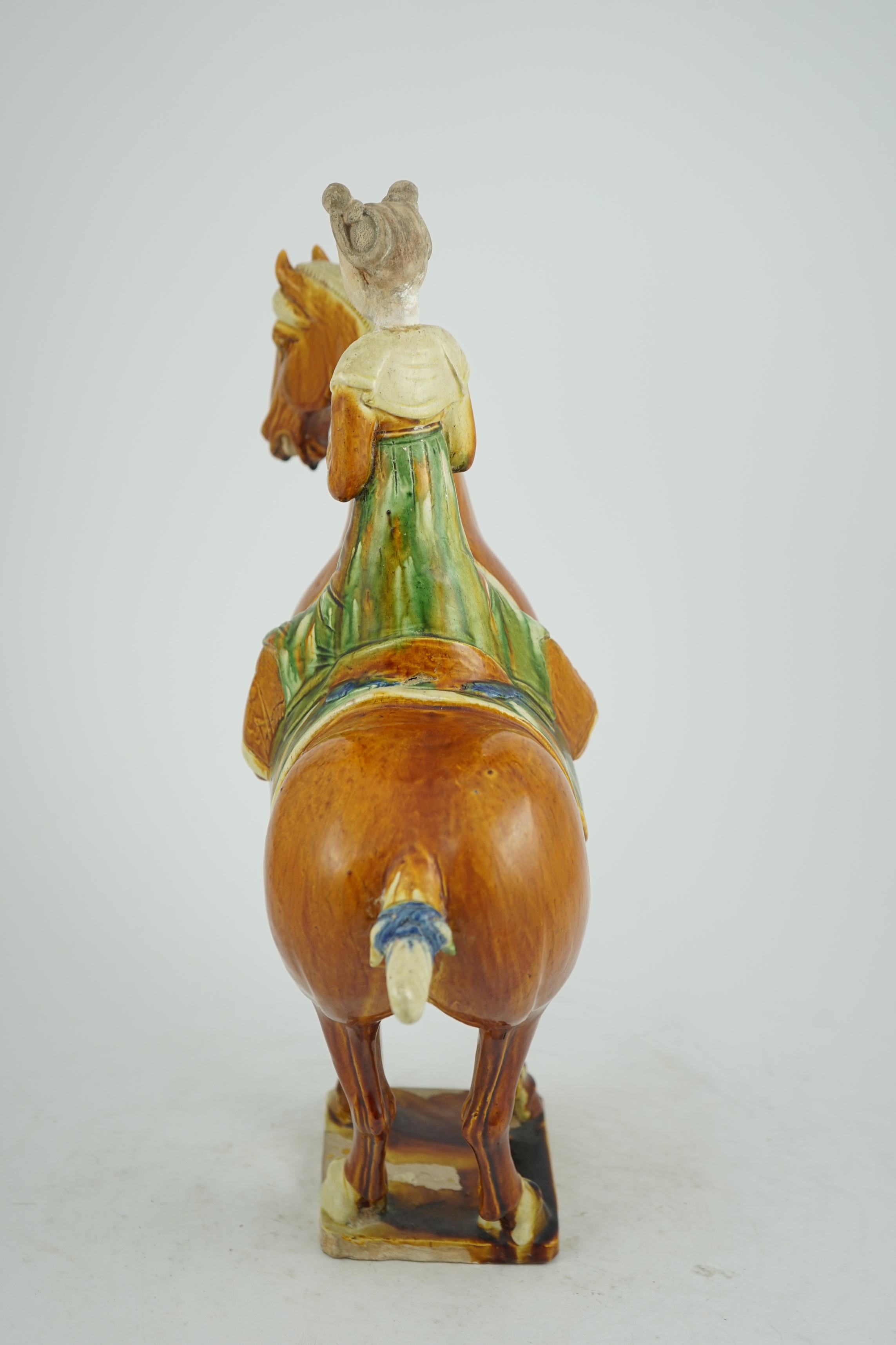 A Chinese sancai glazed group of a horse and female rider, Tang or later